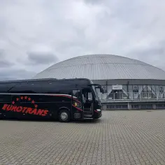 Czarny autokar Eurotrans z czerwonymi gwiazdami i napisem. Zastanawiasz się, ile miejsc ma autokar?