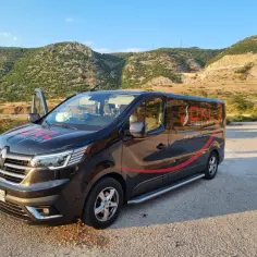 Czarny bus OKL Travel Rent z napisem "Polska-Niemcy-Holandia" na tle gór. Chcesz wiedzieć, ile kosztuje bus do Niemiec? Sprawdź ofertę!