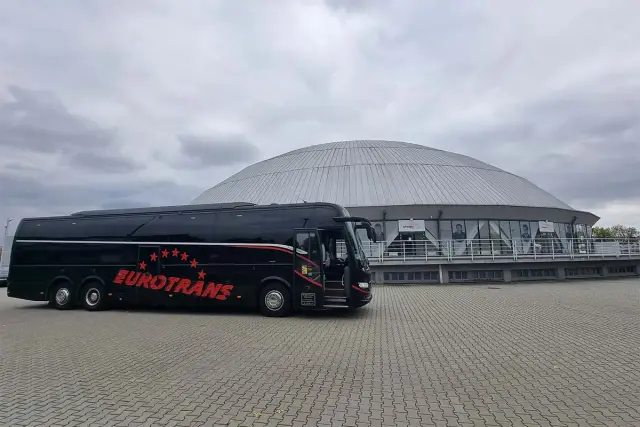 Czarny autokar Eurotrans z czerwonymi gwiazdami i napisem. Zastanawiasz się, ile miejsc ma autokar?
